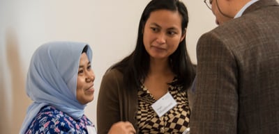 Three participants with name badges in conversation